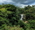 Tall waterfall in tropical forest. Beautiful exotic nature with fresh water stream.