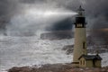 A Tall Whit Lighthouse Shinning Light At Night In A Storm With A Rough Ocean And Fog