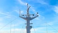A tall, white mast with multiple antennas against a clear blue sky with wispy clouds Royalty Free Stock Photo