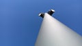 Tall white metal lamppost in the parking lot near the shopping center