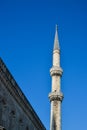 A tall white minaret of a Muslim mosque Royalty Free Stock Photo