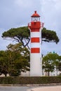 A tall, white and red lighthouse, is located in the picturesque port city Royalty Free Stock Photo