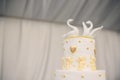 A tall white wedding cake decorated with gold flowers and white swans. Two pieces are cut off. Royalty Free Stock Photo