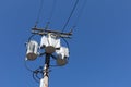 Tall wood electric pole with three transformers against a clear, deep blue sky Royalty Free Stock Photo