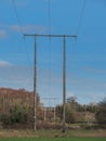 Tall wooden electricity poles against blue sky in nature environment Royalty Free Stock Photo