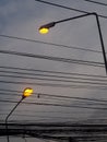 Tall yellow bulb lighting street lamp outdoor silhouette isolated with grey dark cloudy sky