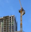 Tall yellow crane working on a large multistory building under construction Royalty Free Stock Photo