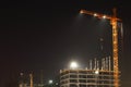 Tall yellow cranes with illumination and building Royalty Free Stock Photo