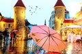 Tallinn autumn rainy evening city light reflection pink umbrella on street old town medieval towels