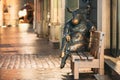 Tallinn, Estonia. Black Angus Sculpture - Bronze Bull Cow Statue That Sitting On Bench Near Cafe. Night View.