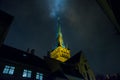 Tallinn, Estonia: Church of St. Olaf. The Church spire is illuminated. Bottom view. Old town with houses at night Royalty Free Stock Photo