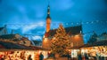 Tallinn, Estonia. Colourful Night Starry Sky In Bright Blue Colors Of Traditional Christmas Market In Town Hall Square