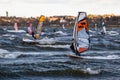 Tallinn, Estonia - October 18, 2008: Many windsurfers ride boards in the waves in the wind.