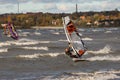 Tallinn, Estonia - October 18, 2008: A windsurfer in a suit rolls along the waves on a board with a sail with a strong slope. Royalty Free Stock Photo