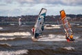 Tallinn, Estonia - October 18, 2008: Windsurfers ride on boards with a sail on the waves at sea.