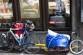 bike is tied on street with original Bicycle trailer. Bicycle bag