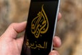 Black phone with logo of news media Al Jazeera on the screen Royalty Free Stock Photo