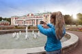 TALLINN, ESTONIA- SEPTEMBER 7, 2015: The woman photographs the Kardiorg palace at Kadriorg Park on phone in Tallinn, Estonia