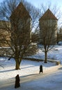 Two women walk in a park in front of the city wall in Tallinn, Estonia