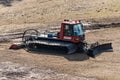 Talsi, Latvia - April 15, 2012: Red modern snowcat ratrack with snowplow snow grooming machine stay in spring day. Heavy machinery