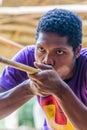 TAMAN NEGARA, MALAYSIA - MARCH 17, 2018: Indigenous man making with a blowpipe in his village in Taman Negara national