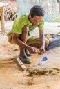 TAMAN NEGARA, MALAYSIA - MARCH 17, 2018: Indigenous man making darts for a blowpipe in his village in Taman Negara