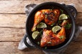 Tamarind chicken quarter leg with lime close-up in a frying pan. horizontal top view