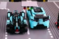 Lego Jaguar I-PACE eTROPHY and Formula E Panasonic Jaguar Racing Gen2 race cars by LEGO Speed Champions on start line. Back view