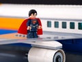Lego Superman minifigure standing on the wing of a Lego passenger airplane Royalty Free Stock Photo