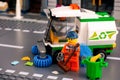 Lego cleaner minifigure with brush cleaning street near street sweeper truck Royalty Free Stock Photo