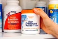 Woman hand taking jar of Pure D-Ribose Powder by Doctor`s Best out of shelf in cupboard