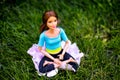 Brunette Barbie doll sitting in the yoga lotus posture on the grass outdoors