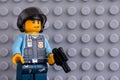 Portrait of Lego policeman minifigure with gun against gray baseplate background