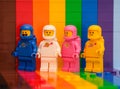 Four Lego astronaut minifigures standing on a rainbow backdrop