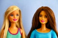 Portrait of two Barbie dolls against blue background