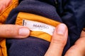 Woman hands holding yellow jacket with Mango Kids clothes label. Royalty Free Stock Photo