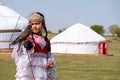 Almaty / Kazakhstan - 09.23.2020 : A little girl in Kazakh national dress holds a Balaban Falcon in her arms