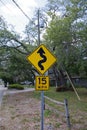 15 Miles Per Hour & squiggly street sign with particial wooden fence