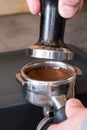Tamper over fresh tamped coffee in portafilter to making espresso