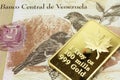 A tan hundred Bolivar note from Venezuela with a gold bar in macro