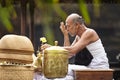 Holly man. A Balinese Hindu religious ceremony leader prays for water to be used for the ceremony