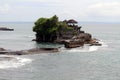 Tanah Lot Temple, rock formation, in the middle of the sea and GWK statue faraway. Royalty Free Stock Photo