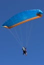 Tandem blue and orange paragliding flight
