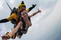 Tandem skydiving. Girl is flying in the cloudy sky. Royalty Free Stock Photo