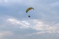 A tandem motor paraglider flies through the evening cloudy sky with a pilot and a passenger. Royalty Free Stock Photo