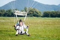 Tandem parachute jump, instructor with an older man at the moment of landing shot