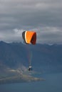 Tandem paraglider flying over lake in cloudy day Royalty Free Stock Photo