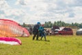 Tandem Paragliding takeoff from the field. Blue sky with clouds