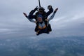 Tandem skydiving in the cloudy sky. Royalty Free Stock Photo