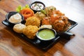 tandoori fried roasted momos dimsum pakora with vegetable flower chicken and green, white and red sauce put in a black Royalty Free Stock Photo